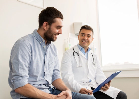 Smiling doctor and young man meeting at hospital