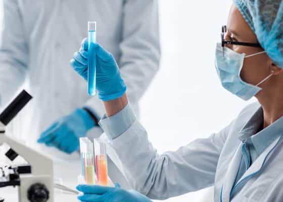 Selective focus of biologist looking at test tube in lab